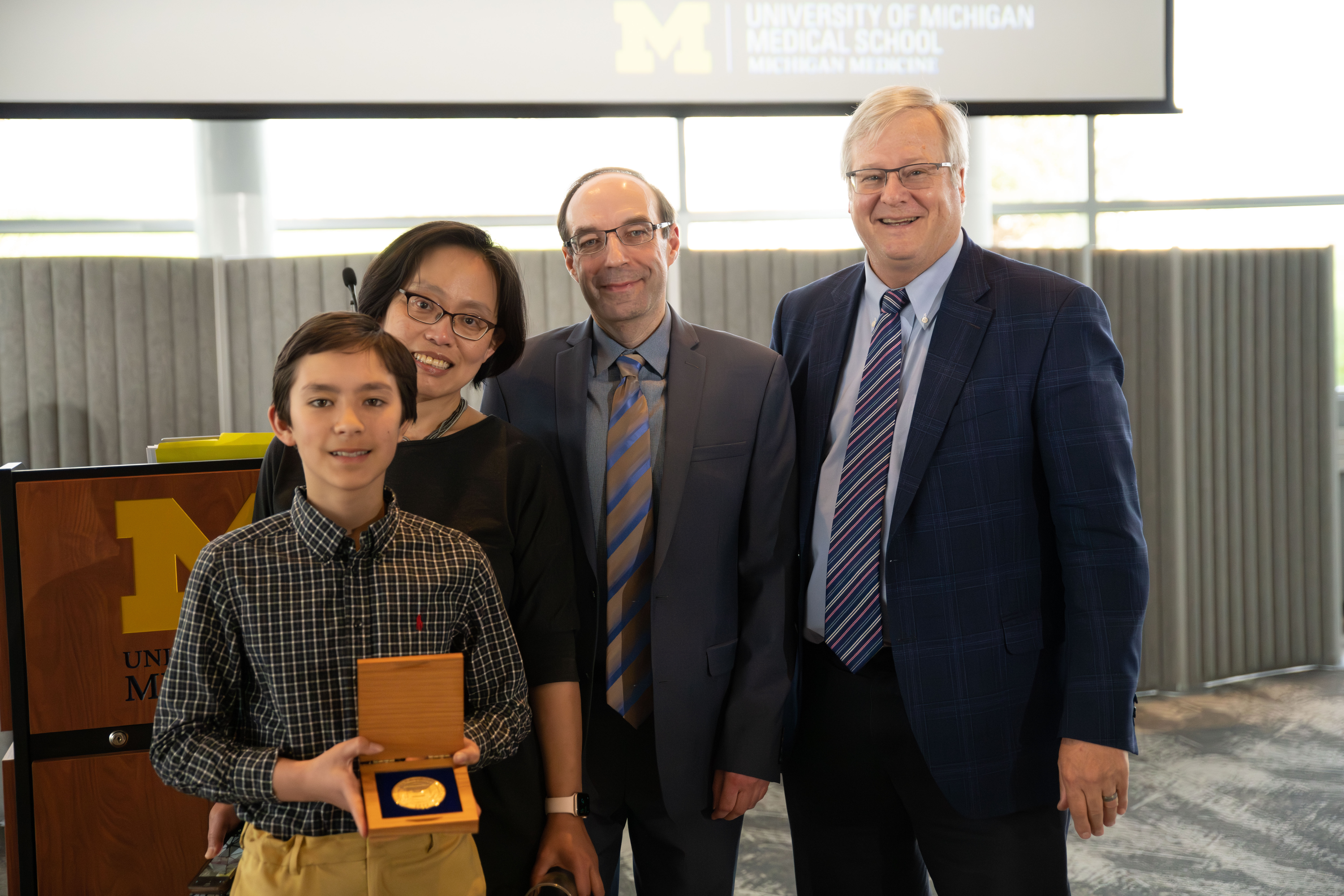 Dr. Alexey Nesvizhskii, with his wife Cindy Lin, son Anatoli Nesvizhskii who proudly displays his dad's professorship medallion, and Dr. Charles Parkos, Chair of Pathology 